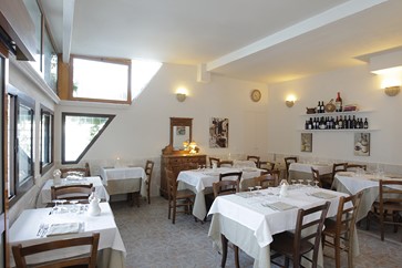 sala interna con tavoli e arredo di legno del ristorante di pesce fresco centro storico di Vieste in piazzetta Petrone